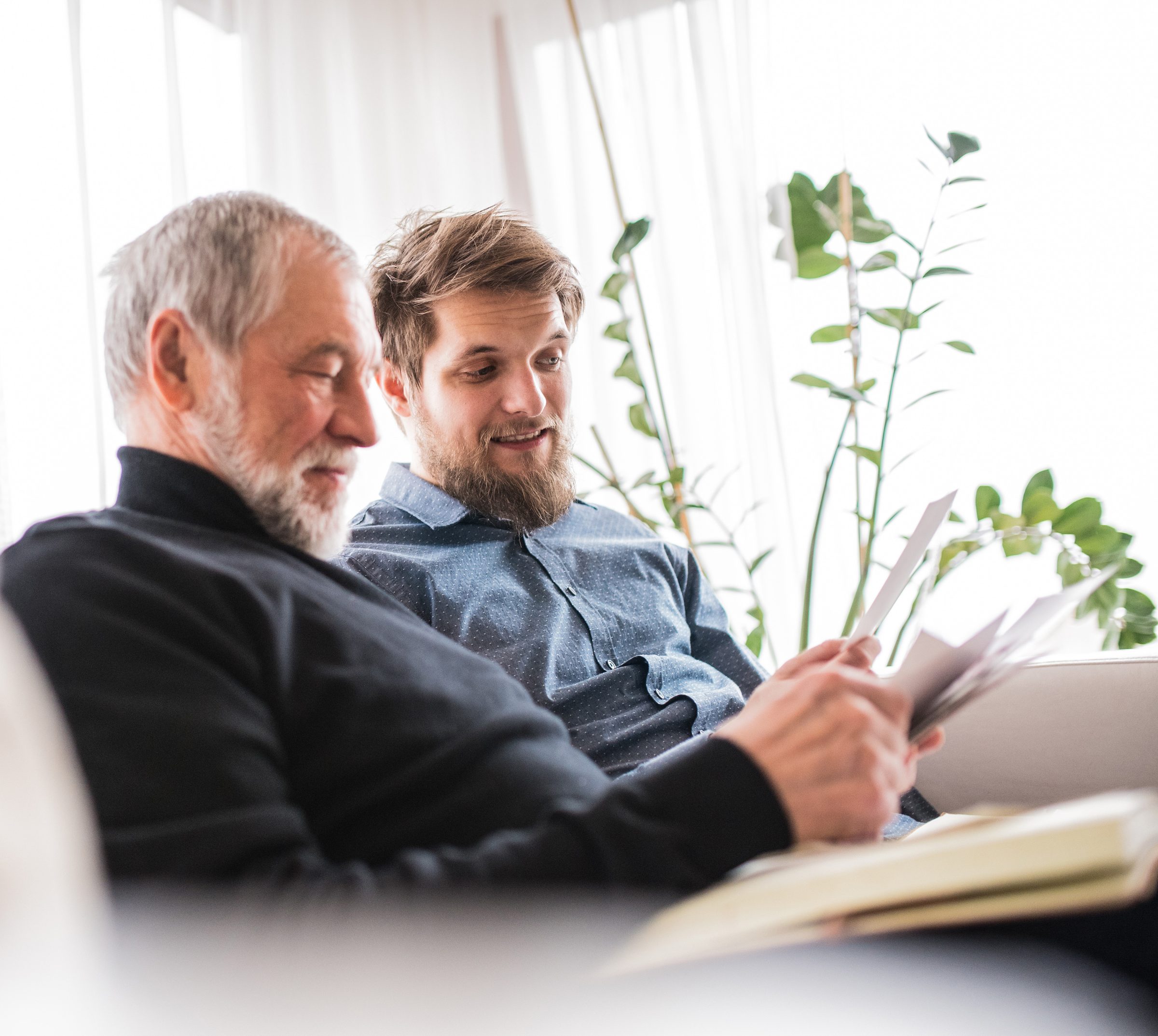 An adult son helping his father review paperwork at home